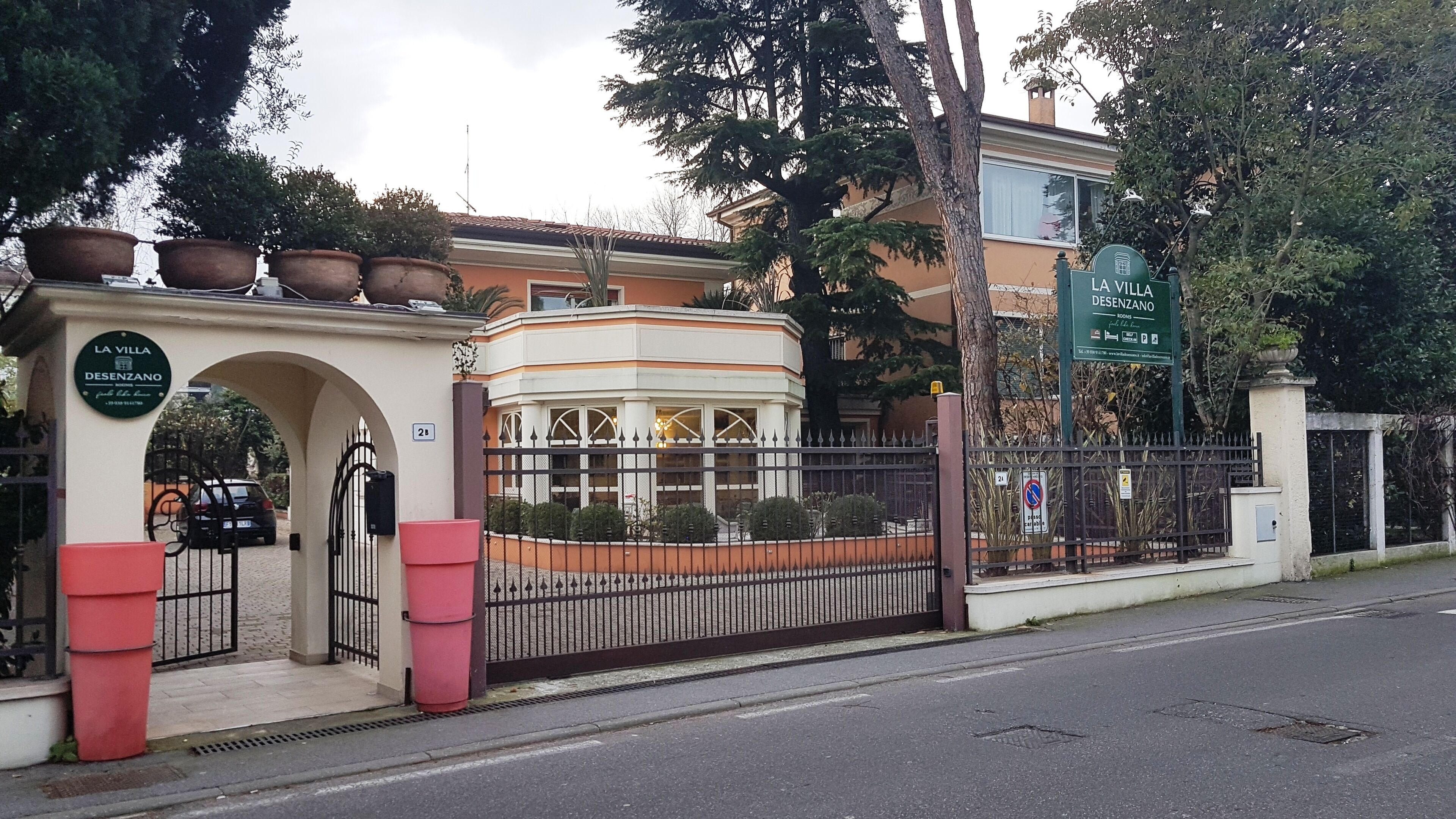 Una entrada portonada a un hotel con un letrero que dice "LA VILLA DESENZANO".