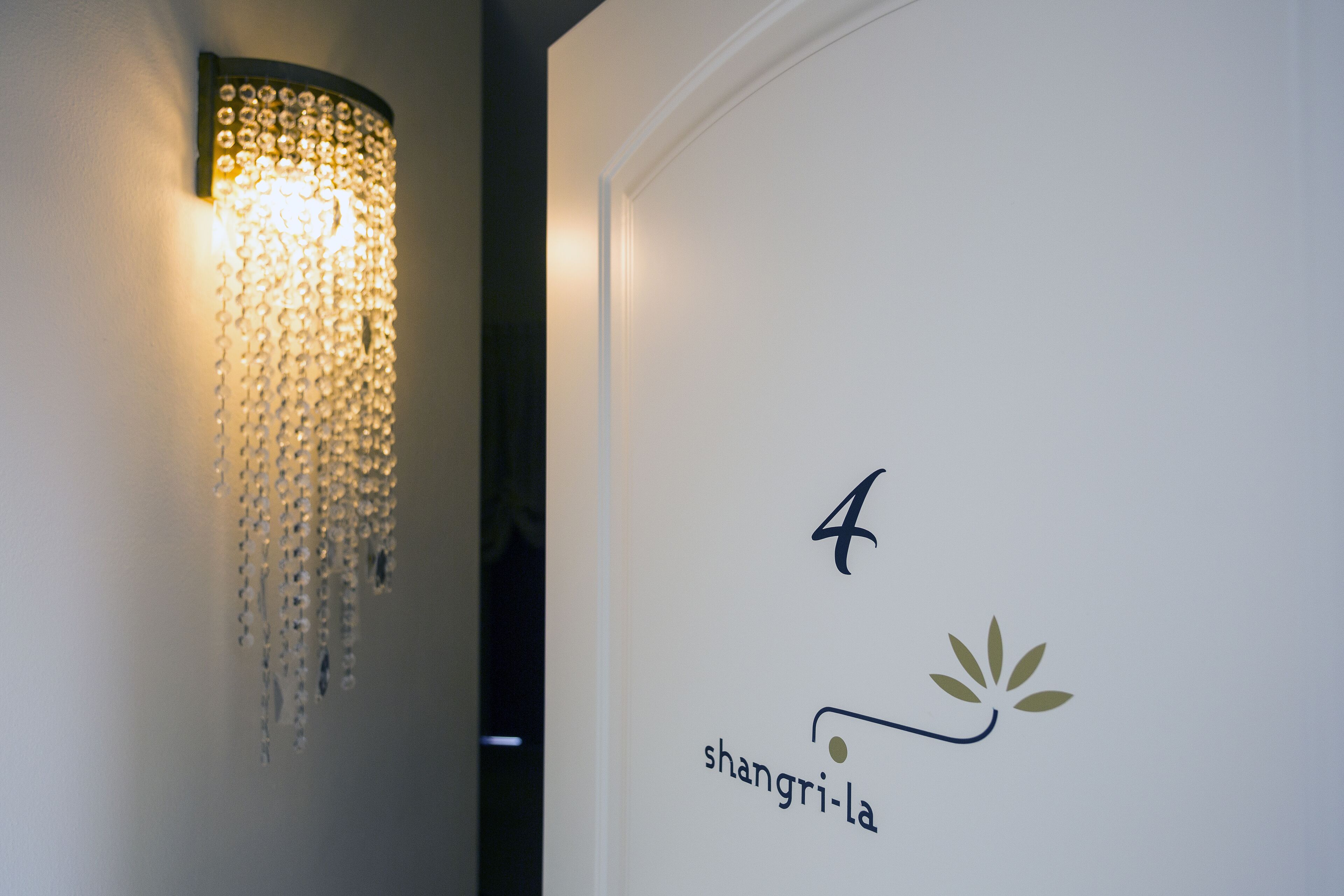 A wall with a chandelier and a logo that reads "4 Shangri-la".