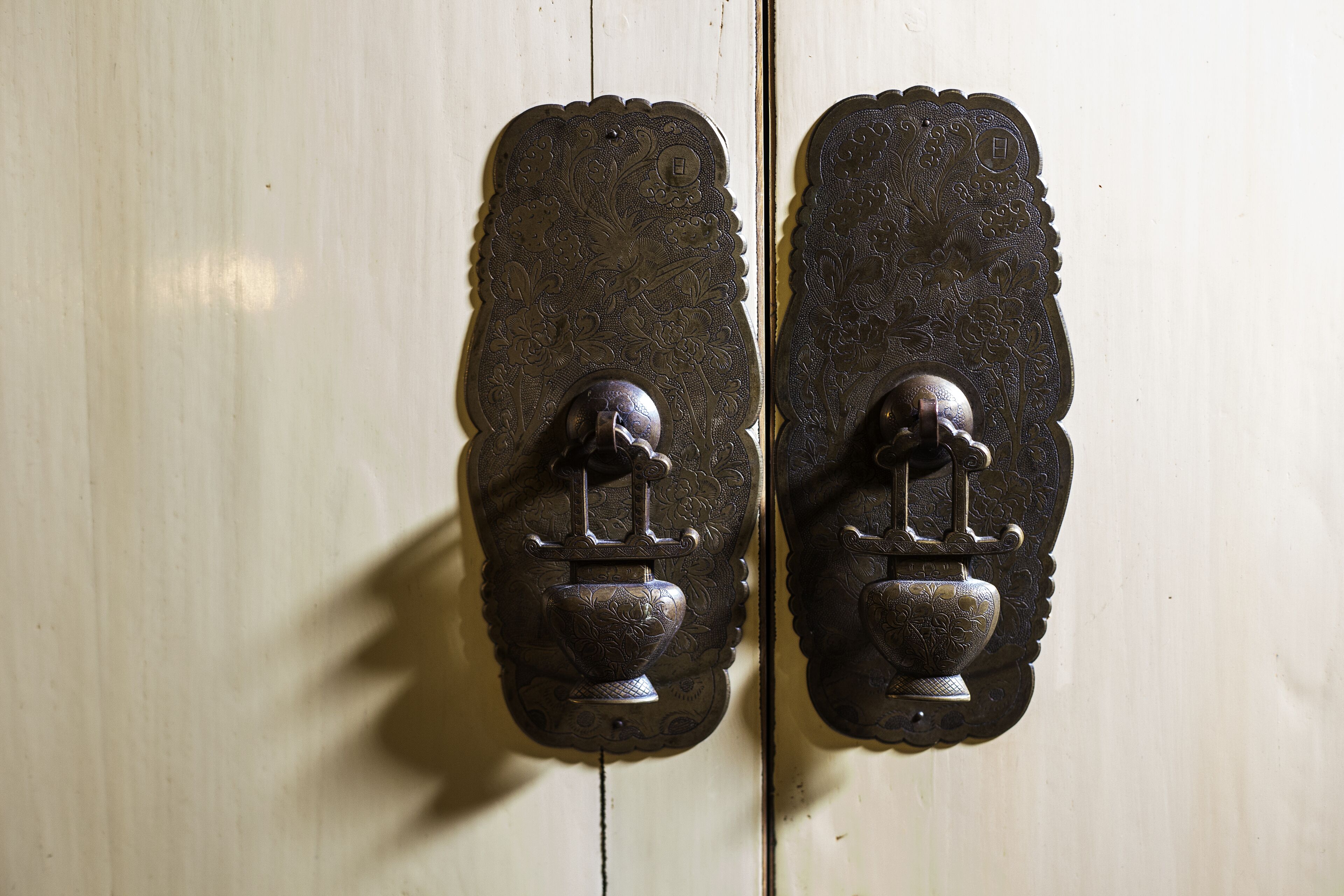 Dos elegantes tiradores de puerta antiguos con diseños intrincados.