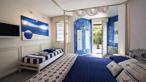 Un dormitorio con una cama grande, una cama más pequeña, un televisor y obras de arte en las paredes.