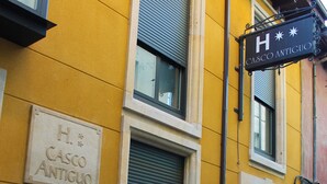 Ein Gebäude mit gelber Fassade, einem Schild mit der Aufschrift "CASCO ANTIGUO" und einem schwarzen Schild mit einem "H" und Sternen.