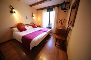 A double bed with a wooden headboard, a bedside table with a lamp, and a chair. - Alda Casco Antiguo (León)