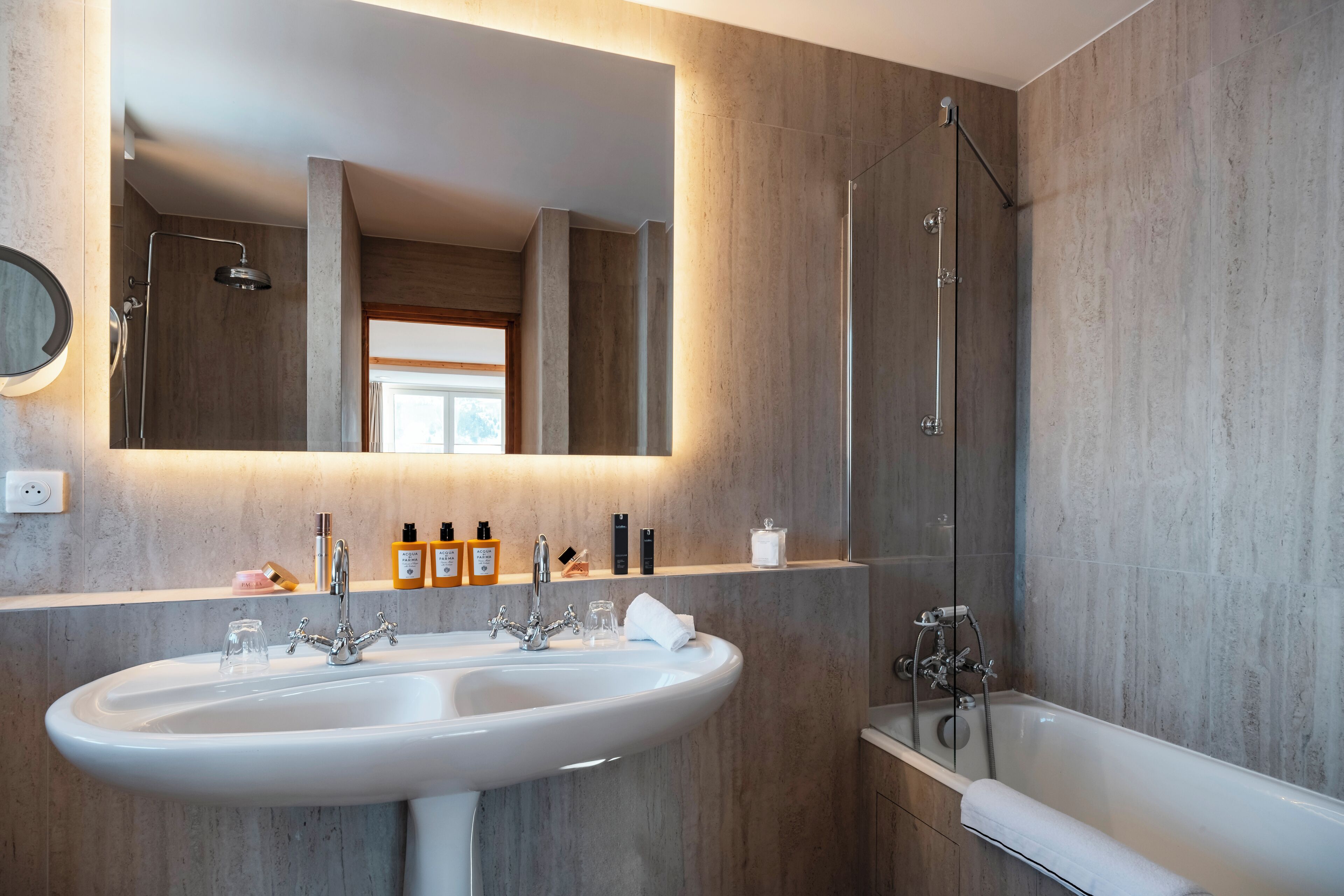 A modern bathroom with a large sink, a mirror, and a bathtub.