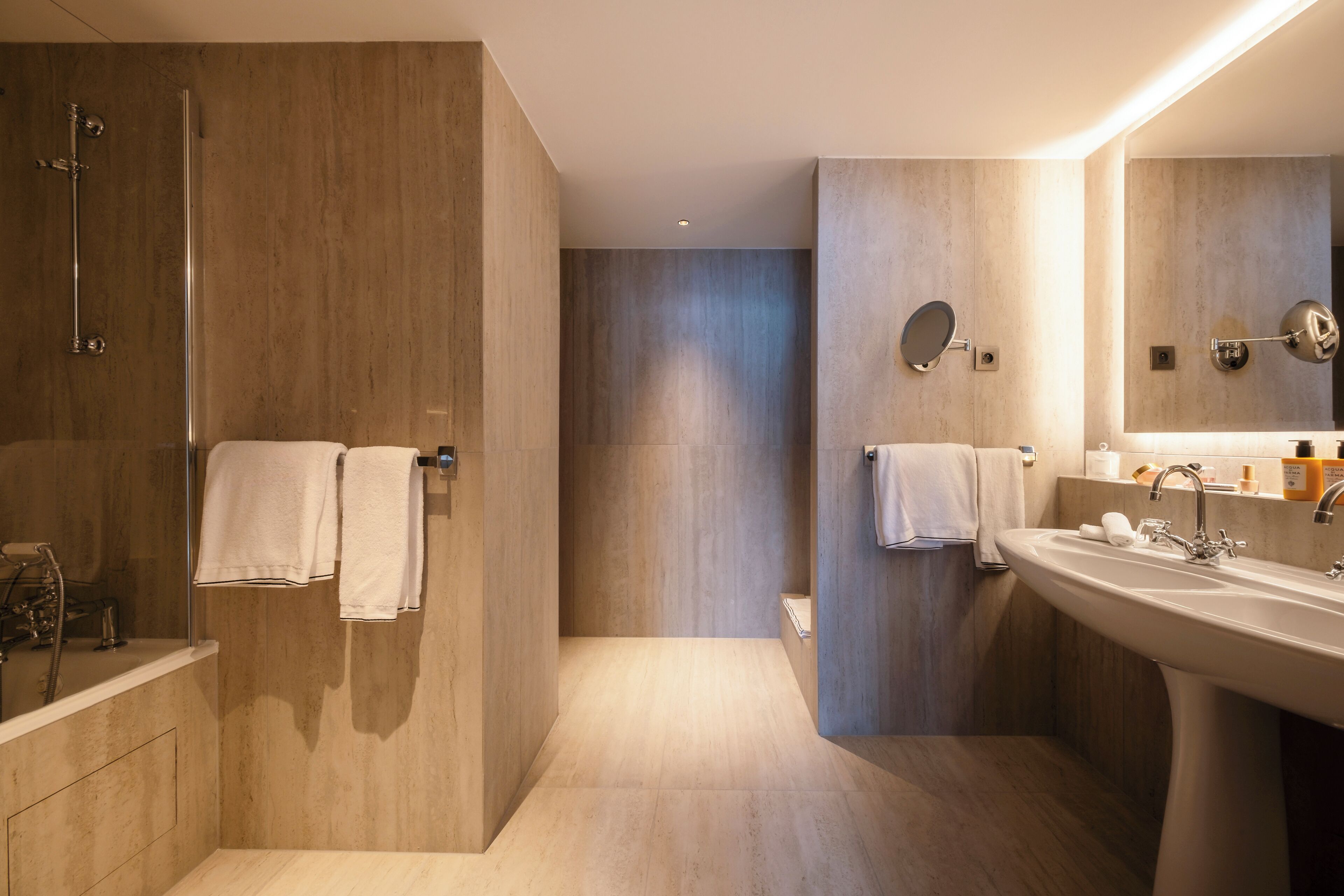 A modern bathroom with a walk-in shower, a large sink, and a mirror.