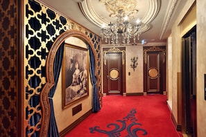 A grand hallway with ornate decorations, a chandelier, and a red carpet. - Daru Sultan Galata (Istanbul)