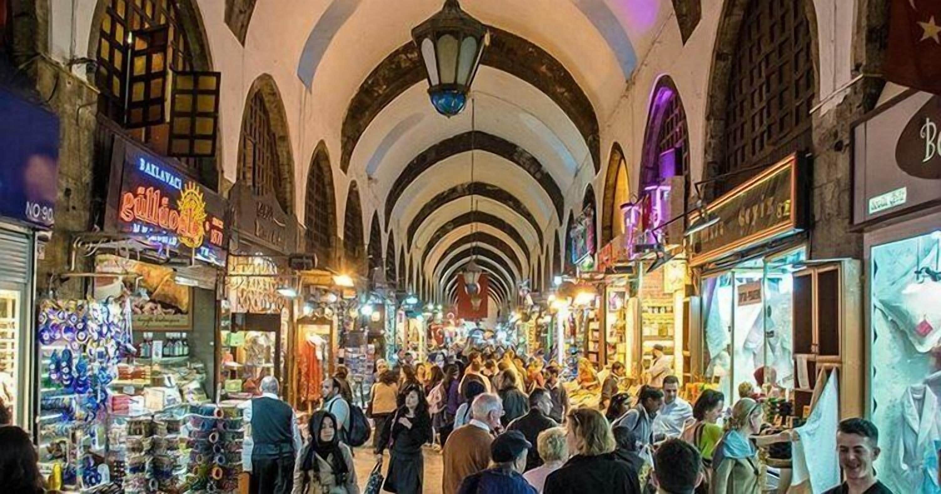 A crowded indoor market with arches and various shops.