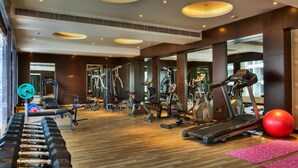 A modern gym with various exercise equipment, including treadmills, elliptical machines, and free weights.