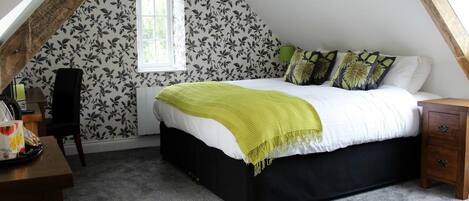 Un dormitorio con cama, ventana y escritorio.