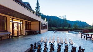 Un jeu d’échecs installé sur une terrasse, avec un bâtiment en arrière-plan.
