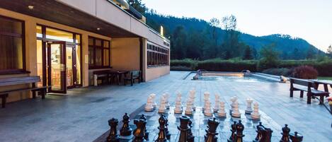 A chessboard set up on a patio with a building in the background.