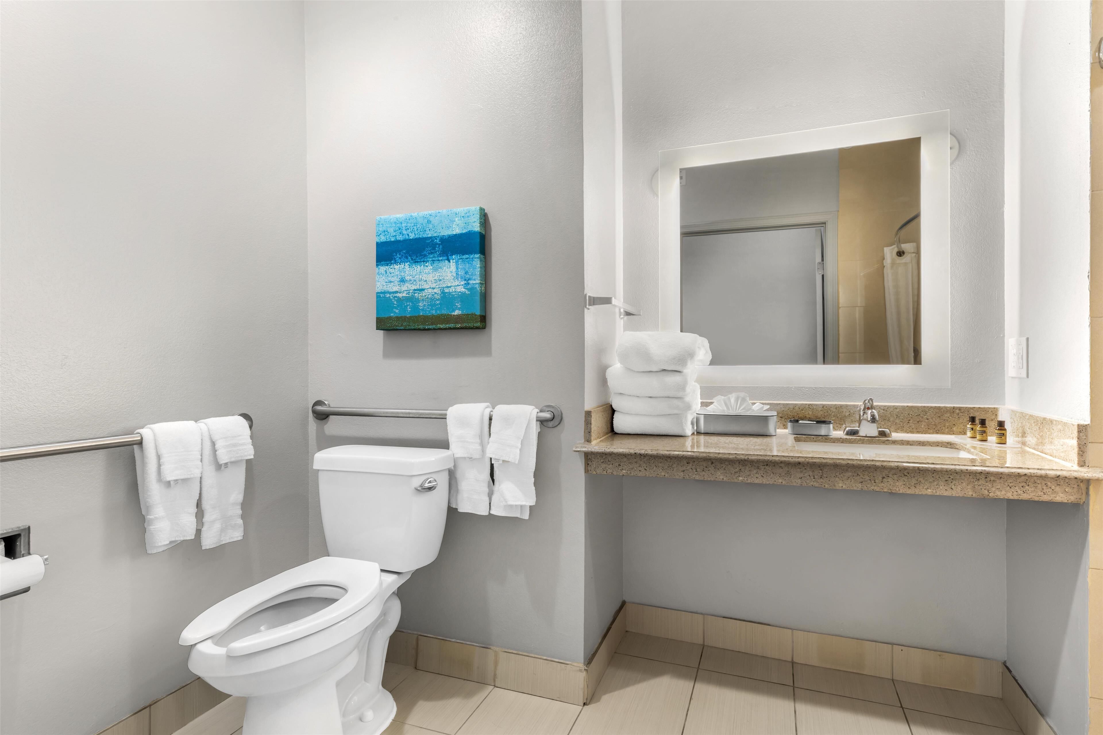 A modern bathroom with a toilet, a sink, and a towel rack.