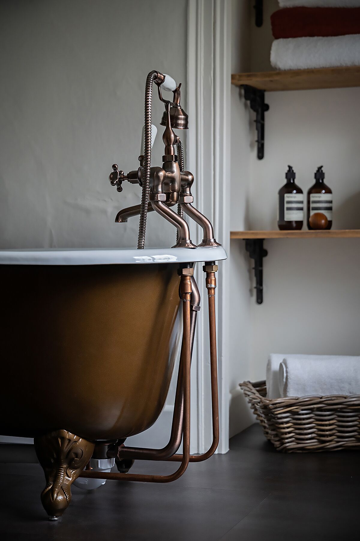 Une baignoire de style vintage, avec des tuyaux en cuivre et un mur blanc en arrière-plan.