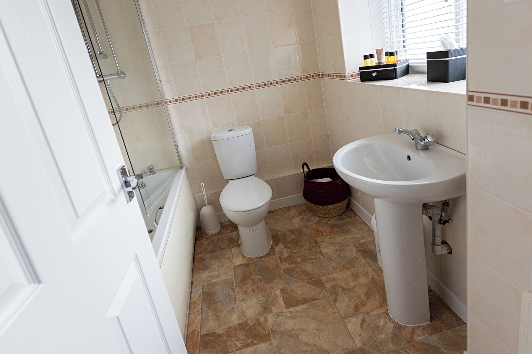 A bathroom with a toilet, sink, and shower.