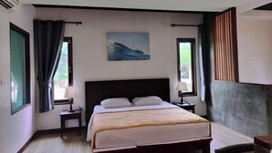 Camera da letto con un letto grande, due comodini, una finestra con tende, un quadro al muro e una lampada a sospensione.