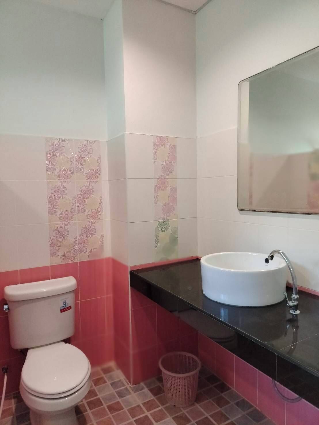 Ein Badezimmer mit Toilette, Waschbecken und Fliesen.