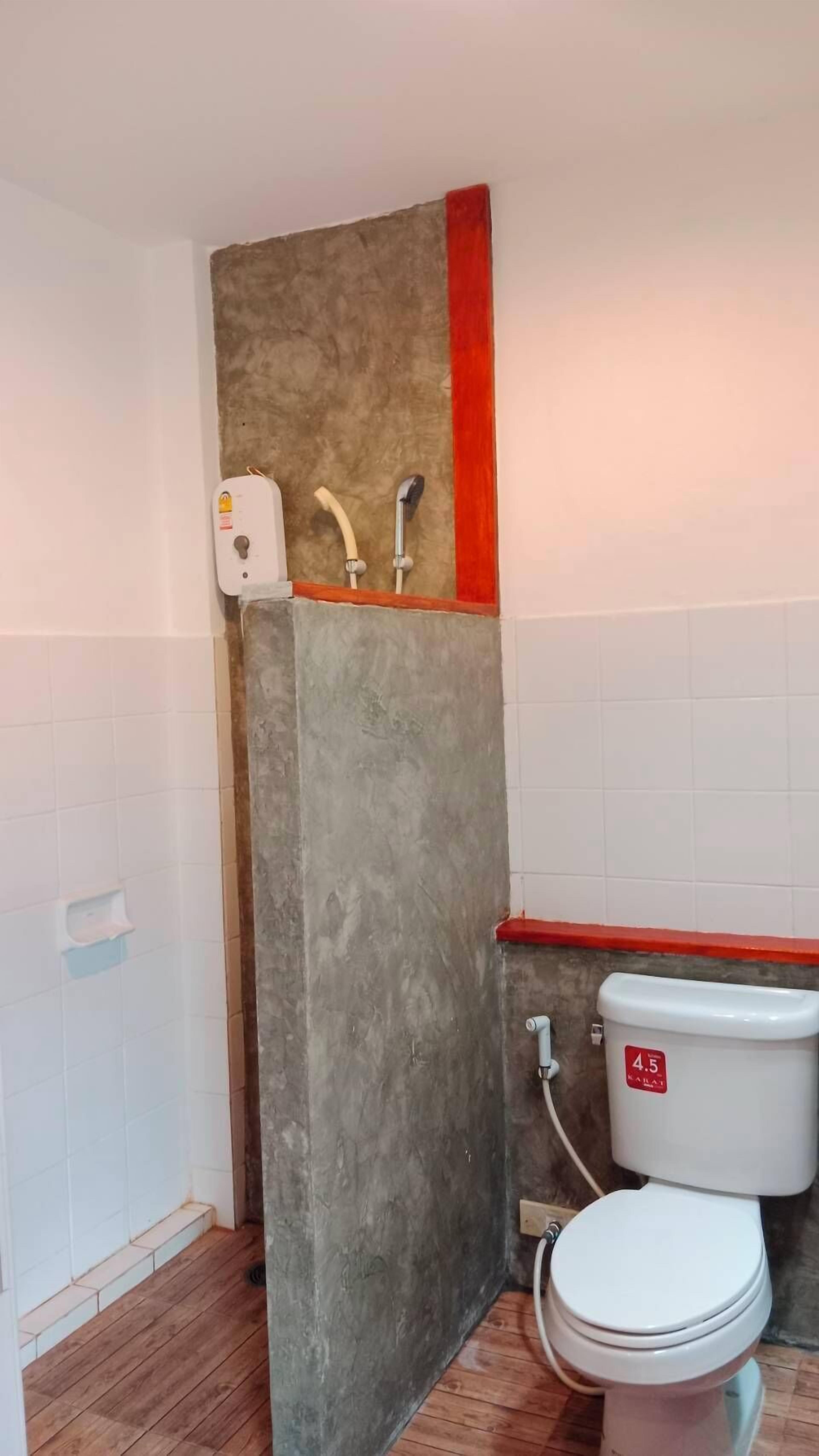 A bathroom with a toilet, a shower, and a hand dryer.