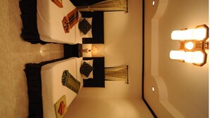 A hotel room with a bed, bedside tables, a wall-mounted light fixture, and a curtain. - N.T. Lanta Resort (Ko Lanta)