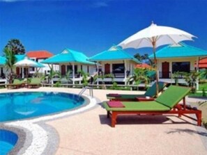A pool area with lounge chairs and umbrellas. - N.T. Lanta Resort (Ko Lanta)