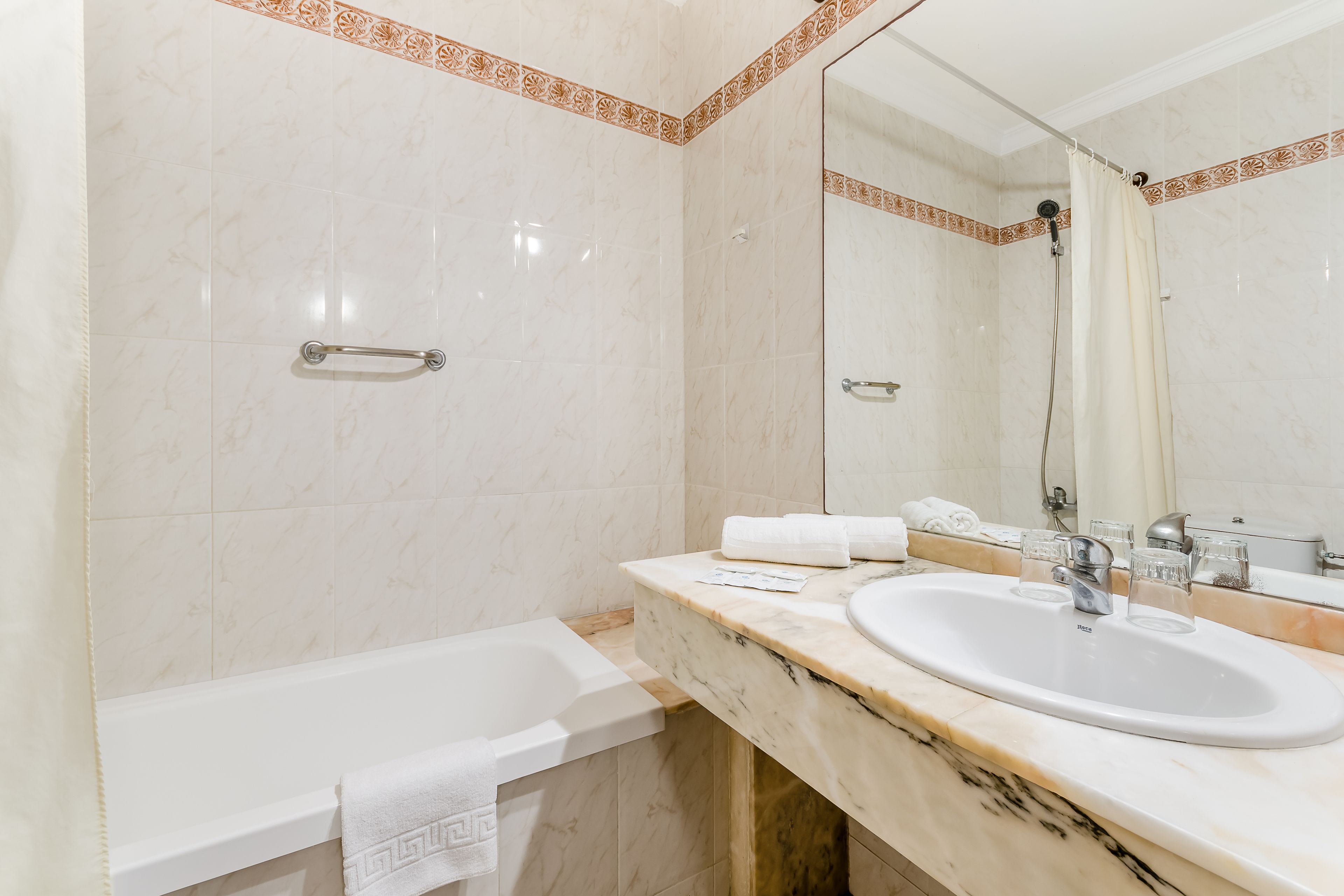 Une salle de bain avec une baignoire, un lavabo et un miroir.