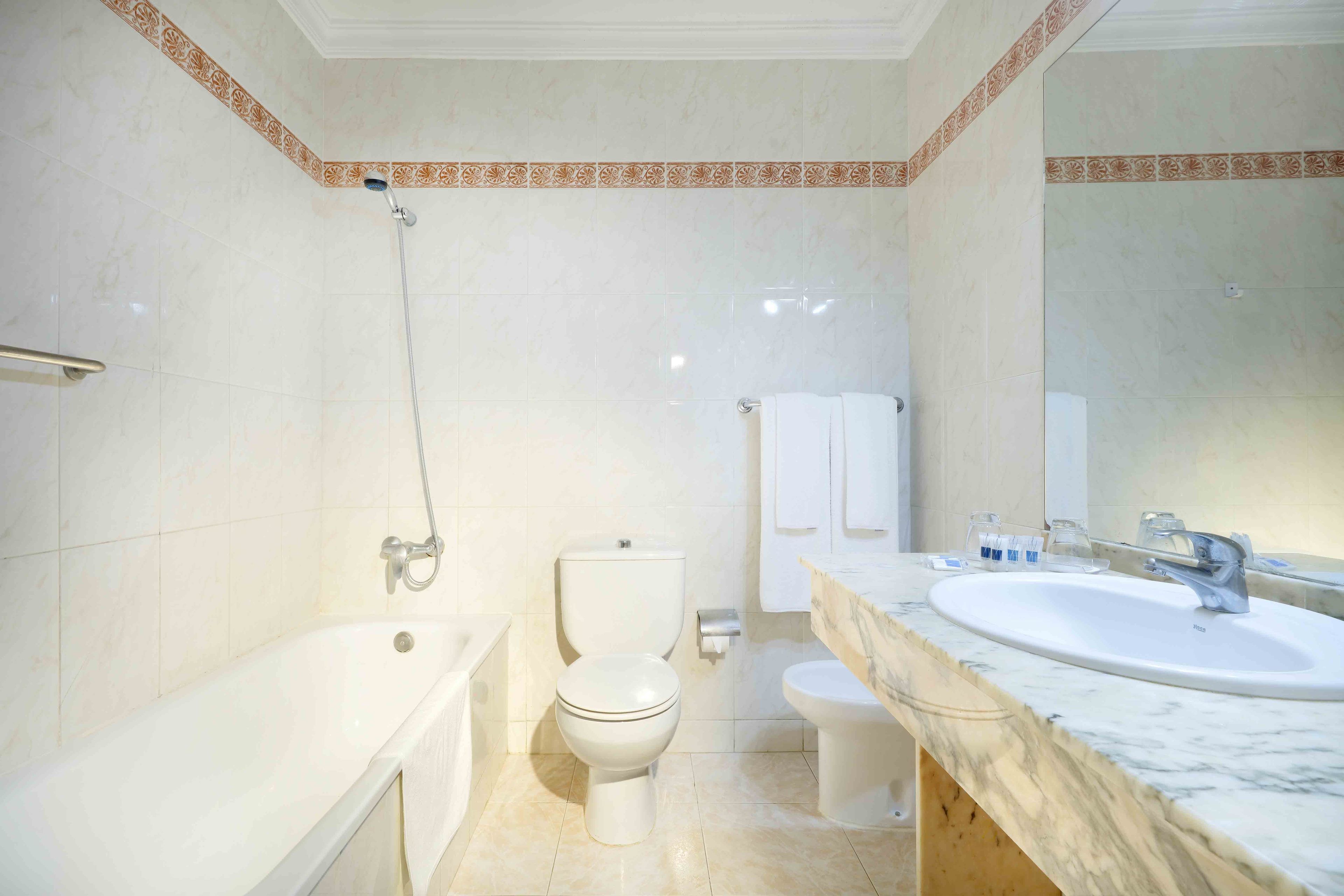 A bathroom with a bathtub, toilet, and sink.