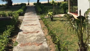 A pathway leading to a building with a red roof, surrounded by greenery and a view of the beach. - Good Days Lanta Beach Resort (Ko Lanta)