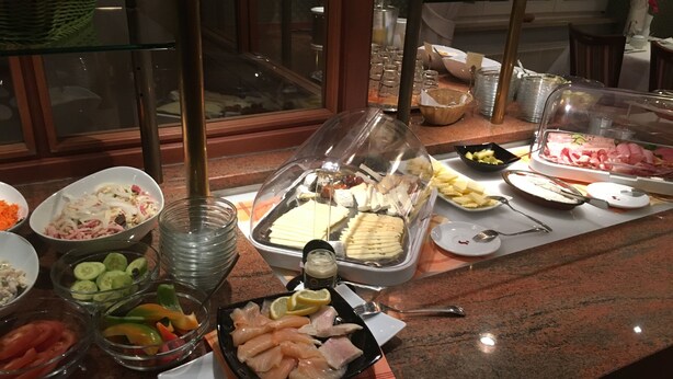 Un bufé con diversos alimentos, como ensaladas, frutas y mariscos.