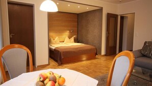 Een slaapkamer met een bed, een eettafel met fruit en een bank.