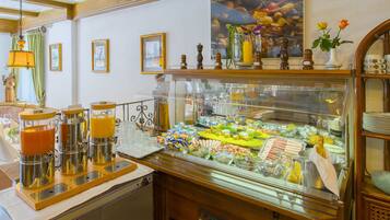 Ein Frühstücksbuffet mit verschiedenen Speisen und einer Kaffeestation.