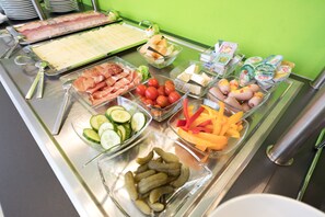 A buffet with various food items including meats, cheeses, vegetables, and condiments. - AMH Airport-Messe-Hotel (Filderstadt)