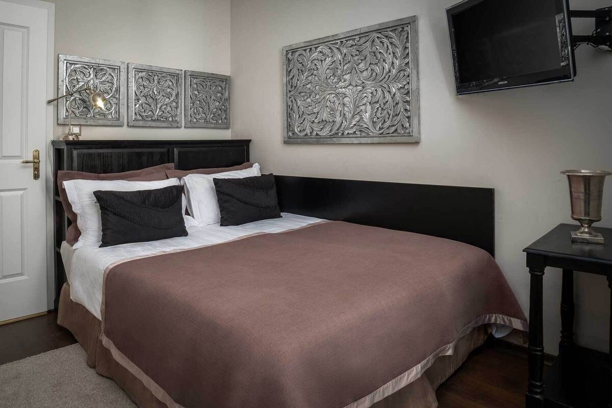 Ein Schlafzimmer mit Bett, Fernseher und dekorativen Wandverkleidungen.