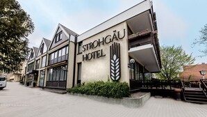 The exterior of the Strohgáu Hotel, featuring a modern facade, large windows, and a prominent sign. - Hotel Strohgäu (Korntal-Munchigan)