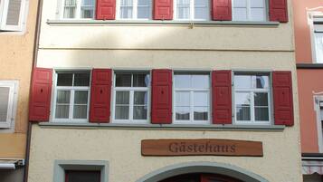 A two-story building with red shutters and a sign that reads "Gästehaus".