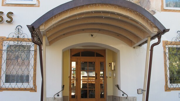 A building with a grand entrance, a staircase leading to the main door, and a mural on the wall. - Almenrausch und Edelweiss (Garmisch-Partenkirchen)