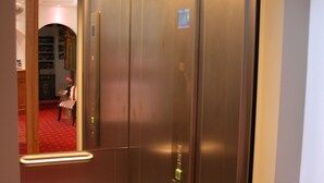 An elevator with metallic walls and a red carpet. - Almenrausch und Edelweiss (Garmisch-Partenkirchen)