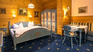 A wooden room with a bed, a table, and a chair. - Almenrausch und Edelweiss (Garmisch-Partenkirchen)