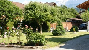 A residential area with a house, a car, and mountains in the background. - Almenrausch und Edelweiss (Garmisch-Partenkirchen)