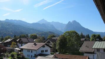 A residential area with houses, a mountain range, and a clear sky.