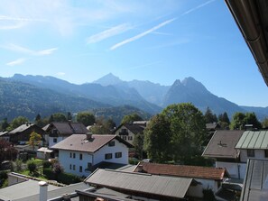 A residential area with houses, a mountain range, and a clear sky. - Almenrausch und Edelweiss (Garmisch-Partenkirchen)