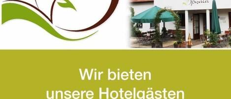 A logo with a leaf and the text "LANDHOTEL" and a photo of a building with outdoor seating and a sign that reads "Bywald".