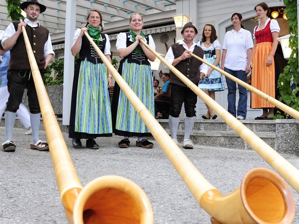 Un groupe de personnes vêtues de costumes traditionnels se tient sur des marches, avec des instruments de musique en bois disposés au premier plan.