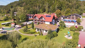 Un hôtel comprenant plusieurs bâtiments, une piscine et un paysage verdoyant luxuriant.