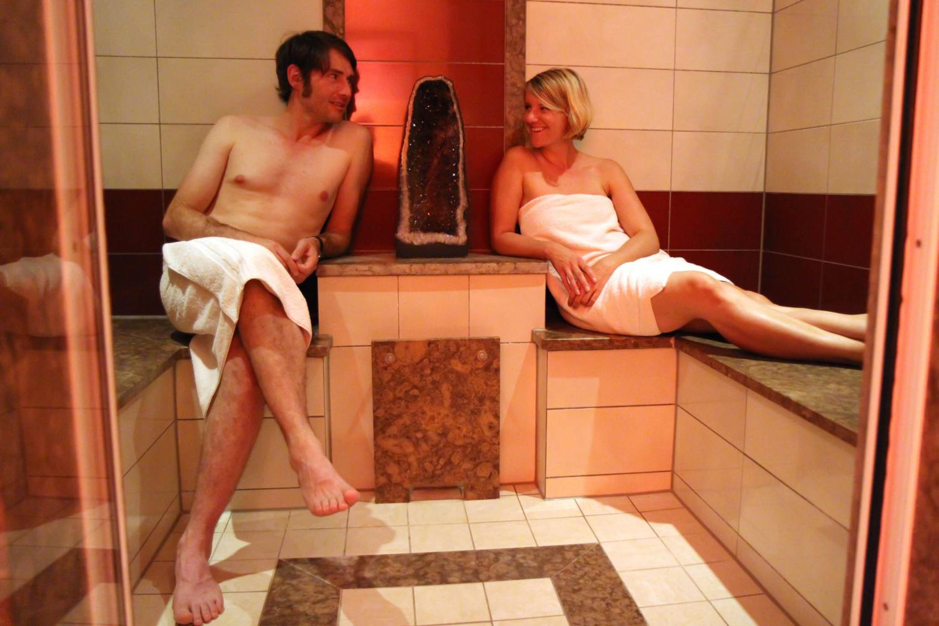 A small, tiled bathroom with a shower area and a bench.
