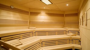 Un sauna doté de plusieurs bancs disposés en arc de cercle.