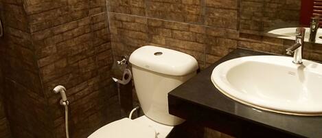 A bathroom with a toilet, sink, and shower.