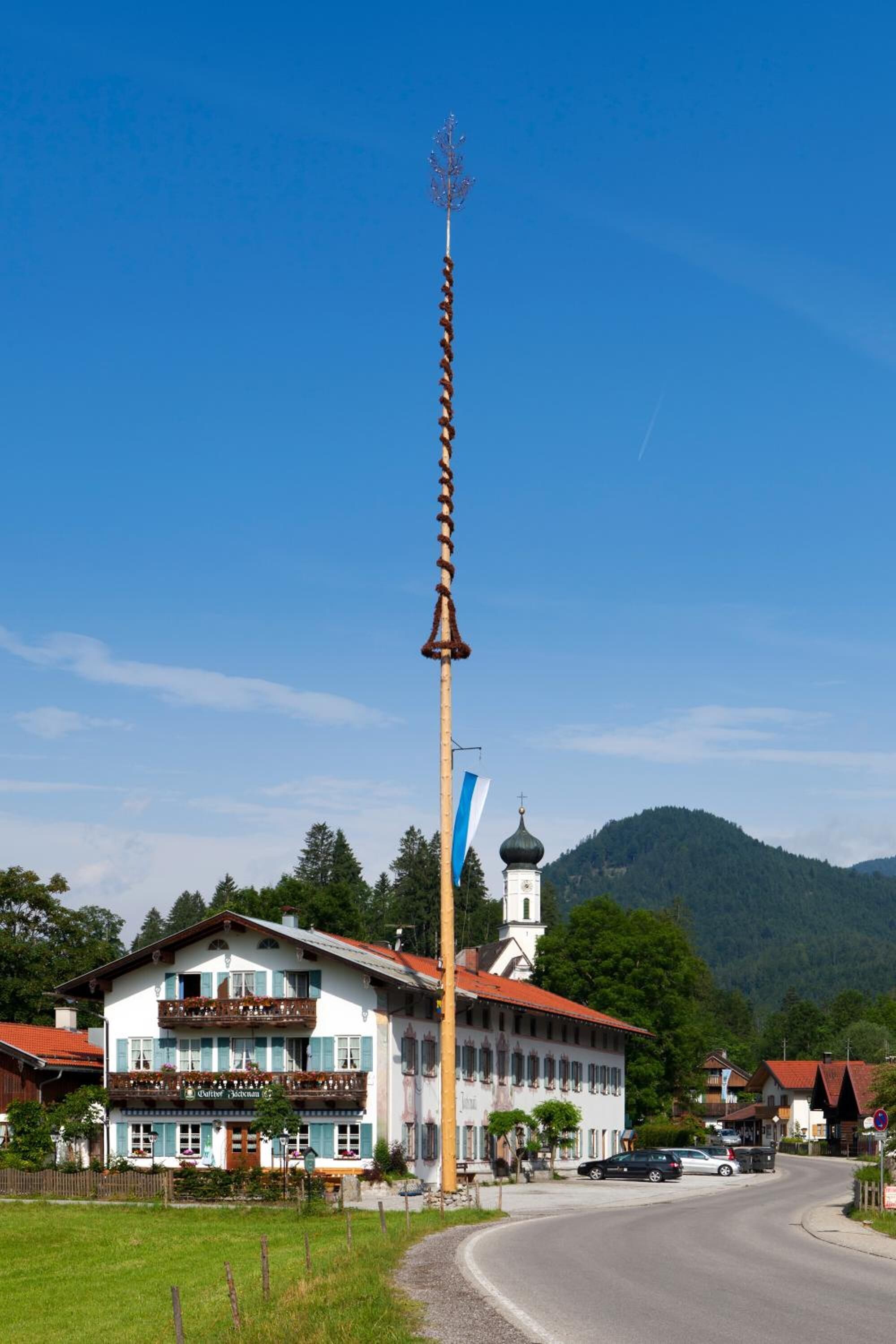 Un edificio tradicional con un campanario, un cartel y una bandera.