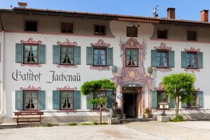 A building with multiple windows, a bench, and a sign that reads "Balthot Jachernau." - Hotel Gasthof Jachenau (Jachenau)