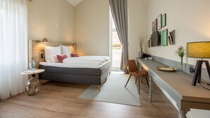 A modern hotel room with a bed, bedside table, lamp, and a desk with a chair. - Hotel, Restaurant und Weinhandel Weinbek (Fockbek)