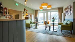 A hotel lobby with a bar area, seating, and a large window offering a view. - Hotel, Restaurant und Weinhandel Weinbek (Fockbek)