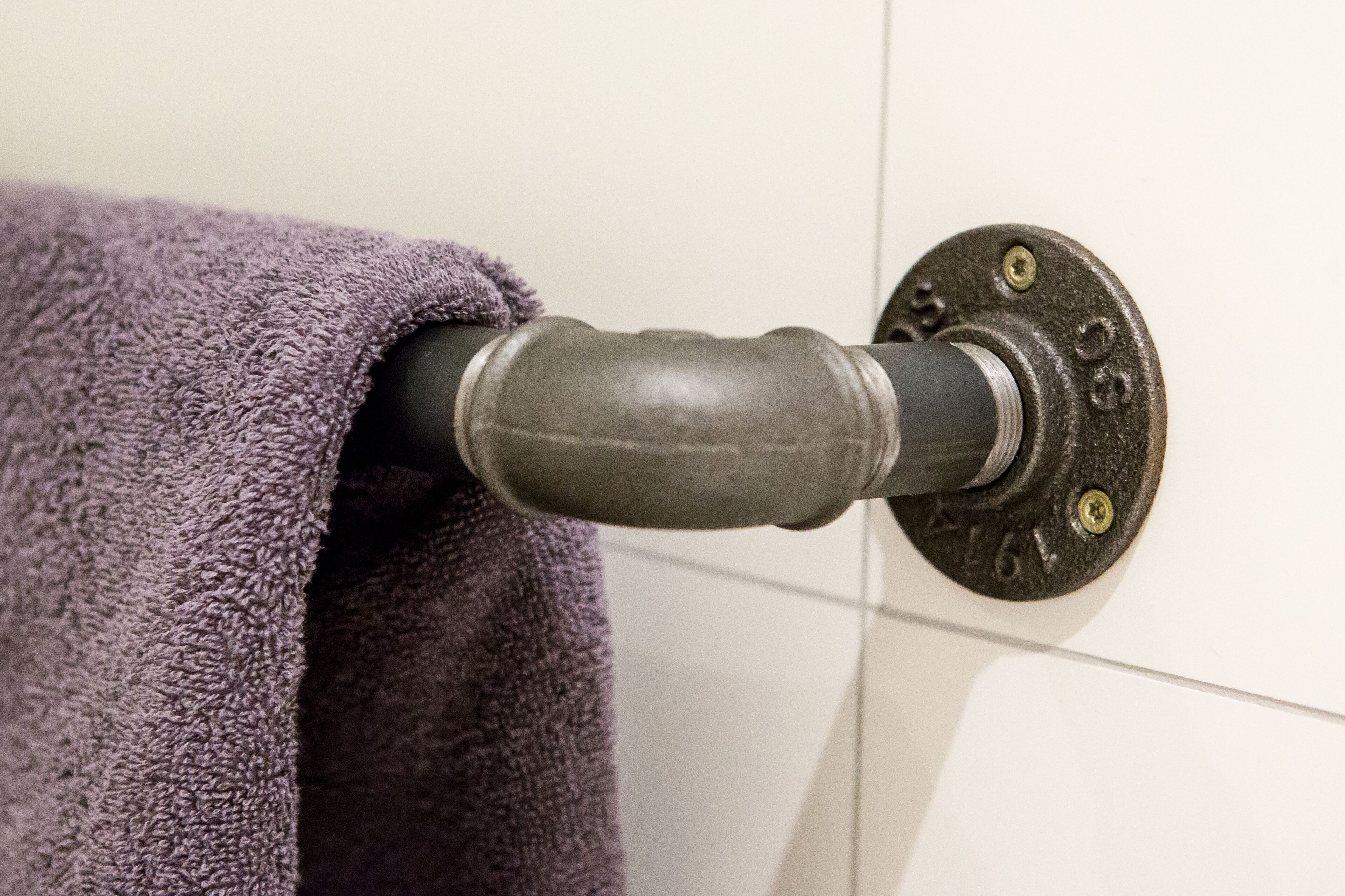 A towel rack with a purple towel hanging on it.