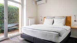 Un dormitorio con cama, ventana y aire acondicionado.